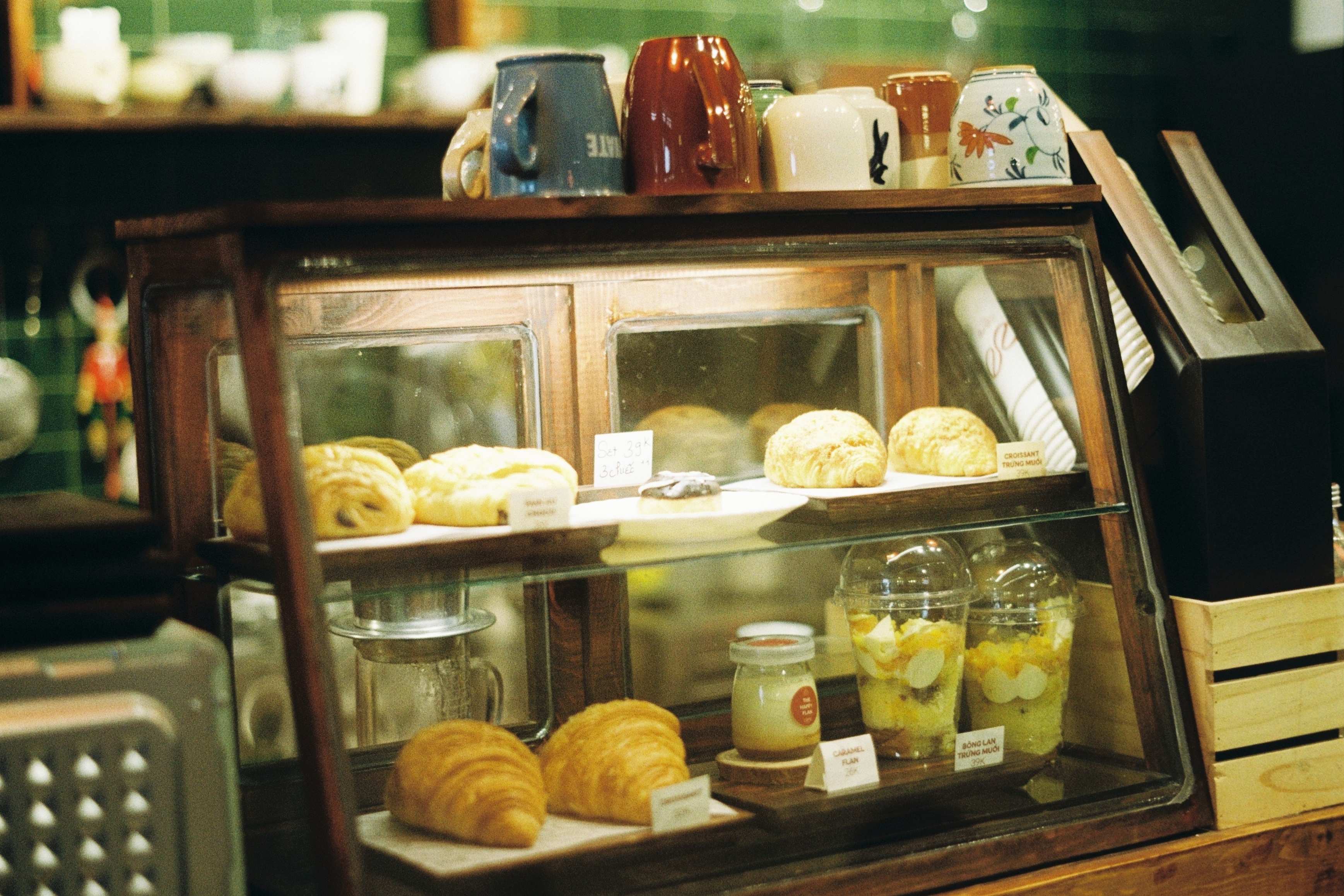 Bakery display case with pastries and cups